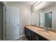 Bright bathroom featuring a modern vanity, a large mirror, and a white paneled door at 1197 Tallow Rd, Apopka, FL 32703