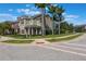 Attractive townhouse with a well-kept lawn, palm trees, and a red front door at 1197 Tallow Rd, Apopka, FL 32703