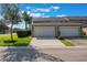 Townhouse featuring a two-car garage, well-maintained lawn, and neatly trimmed bushes at 1197 Tallow Rd, Apopka, FL 32703
