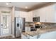 Modern kitchen with stainless steel appliances, granite countertops, and white cabinets at 1197 Tallow Rd, Apopka, FL 32703
