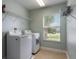 Convenient laundry room with modern washer and dryer units, metal shelving, and a bright window at 1197 Tallow Rd, Apopka, FL 32703