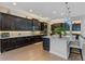 Well-equipped kitchen with a large island, granite countertops, dark wood cabinetry, and modern lighting at 1491 Gateway Ln, Kissimmee, FL 34746