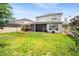 Large backyard features a well-maintained lawn, screened lanai, and outdoor kitchen with pergola at 1638 Swallowtail Ln, Sanford, FL 32771