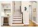 Hallway with stairs and a built-in bar area with a wine fridge at 1638 Swallowtail Ln, Sanford, FL 32771
