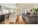 Open concept living room features hardwood floors, a large sofa and backyard access at 1638 Swallowtail Ln, Sanford, FL 32771