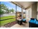 Relaxing screened patio featuring a fire pit, cozy seating, and a view of the backyard oasis with a built-in grill at 1638 Swallowtail Ln, Sanford, FL 32771