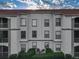 Three-story exterior of building shows multi-pane windows, white siding and a red tile roof at 2615 Maitland Crossing Way # 9 307, Orlando, FL 32810
