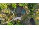 Aerial view showing the house, driveway, pool, and pond surrounded by mature trees at 305 Sweetwater Club Cir, Longwood, FL 32779