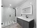 Modern bathroom boasts marble walls, walk-in shower with black fixtures, and an LED mirror over a floating vanity at 305 Sweetwater Club Cir, Longwood, FL 32779