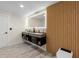 Modern bathroom featuring double floating sinks, LED mirror, and accent wood detail at 305 Sweetwater Club Cir, Longwood, FL 32779