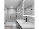 Modern bathroom features marble walls, walk-in shower with black fixtures, and an LED mirror over a floating vanity at 305 Sweetwater Club Cir, Longwood, FL 32779