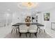 Dining room with a view into the kitchen, modern lighting, black table, and white chairs at 305 Sweetwater Club Cir, Longwood, FL 32779