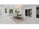 Bright dining room with modern lighting, large windows and doors, and a view to the kitchen at 305 Sweetwater Club Cir, Longwood, FL 32779
