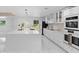 Bright white kitchen featuring stainless steel appliances, a large island and modern fixtures at 305 Sweetwater Club Cir, Longwood, FL 32779