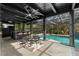Inviting outdoor living space with a dining area, bar, and view of the pool with waterfall at 305 Sweetwater Club Cir, Longwood, FL 32779