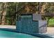 Swimming pool with a modern tiled waterfall feature and mature landscaping at 305 Sweetwater Club Cir, Longwood, FL 32779