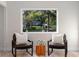 Cozy sitting area features two leather chairs, a wood table and a large window with scenic neighborhood views at 305 Sweetwater Club Cir, Longwood, FL 32779