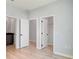 Well-lit bedroom with multiple doorways, wood-look floors, and access to an attached kitchen space at 3397 Tranquil Trl, Kissimmee, FL 34747