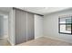 Bright bedroom with light wood floors, a large window, and a modern sliding-door closet at 3397 Tranquil Trl, Kissimmee, FL 34747
