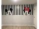 Charming room with black and white stripes, faux brick, and Mickey Mouse and Minnie Mouse painted on the wall at 3397 Tranquil Trl, Kissimmee, FL 34747