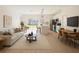 Bright, open-concept living room featuring a modern sofa, breakfast bar, and a view of the backyard at 3553 Sw 157Th Loop, Ocala, FL 34473