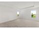 Spacious carpeted bedroom filled with natural light from the two windows and a tray ceiling at 640 Royal Palm Dr, Dundee, FL 33838