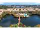 Beautiful aerial view of lakeside townhomes, clubhouse, and pool in a tropical, landscaped community at 728 Greybull Run, Lake Mary, FL 32746