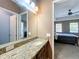 Stylish bathroom vanity with granite counters, mirror, and a glimpse into an adjacent bedroom at 728 Greybull Run, Lake Mary, FL 32746