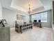 Dining room with modern chandelier, large window, and a rustic dining set at 728 Greybull Run, Lake Mary, FL 32746