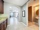 Hallway leading to the living area and powder room, with neutral wall paint and tile floors at 728 Greybull Run, Lake Mary, FL 32746