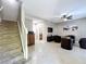 Open living room featuring tile flooring, staircase, and seamless access to an adjacent bathroom at 728 Greybull Run, Lake Mary, FL 32746