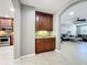 Open-concept living space featuring a dry bar with granite counters, cabinetry and access to the kitchen and living room at 728 Greybull Run, Lake Mary, FL 32746