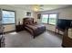 Relaxing bedroom with plush carpet, a ceiling fan, and natural light from two windows at 1016 Monroe Ave, St Cloud, FL 34769