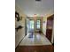 Inviting foyer with tile flooring, complemented by a decorative shelf and view of the front yard at 1016 Monroe Ave, St Cloud, FL 34769