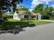 View of a lovely single-story home featuring a well-kept lawn and mature trees in a serene setting at 1016 Monroe Ave, St Cloud, FL 34769