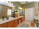A bathroom with double vanity, wood cabinets, a stone accent wall, and tile floor at 11314 Ledgement Ln, Windermere, FL 34786