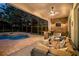 Relaxing screened-in patio featuring a comfortable seating area, stone accent wall, and a view of the pool at 11314 Ledgement Ln, Windermere, FL 34786