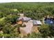 Extensive aerial view of the property featuring lush landscaping, pond, pool and custom home at 11450 Nellie Oaks Bnd, Clermont, FL 34711