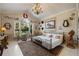 This bedroom showcases a vaulted ceiling, elegant chandelier, and a cozy seating area by the window at 11450 Nellie Oaks Bnd, Clermont, FL 34711