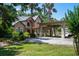 Elegant home with porte cochere, complemented by lush landscaping and stately palm trees at 11450 Nellie Oaks Bnd, Clermont, FL 34711
