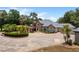 Stunning exterior elevation of a well-manicured home with a circular driveway and water fountain at 11450 Nellie Oaks Bnd, Clermont, FL 34711