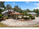 Elegant home with portico, circular driveway, fountain, and multi-car garage, surrounded by trees at 11450 Nellie Oaks Bnd, Clermont, FL 34711