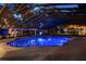 An outdoor pool illuminated in blue at dusk, offering a serene and inviting atmosphere for relaxation at 11450 Nellie Oaks Bnd, Clermont, FL 34711