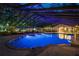 A covered pool illuminated in blue at dusk, offering a serene and inviting atmosphere for relaxation at 11450 Nellie Oaks Bnd, Clermont, FL 34711