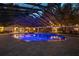 A covered pool illuminated in blue at dusk, offering a serene and inviting atmosphere for relaxation at 11450 Nellie Oaks Bnd, Clermont, FL 34711
