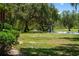Outdoor volleyball court surrounded by lush greenery and mature trees, perfect for recreational activities at 11450 Nellie Oaks Bnd, Clermont, FL 34711