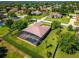 Expansive aerial view of a home with a screened pool and lush green lawn in a well-maintained neighborhood at 11720 Indian Hills Ln, Clermont, FL 34711