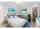 Cozy bedroom with beach themed art, soft lighting, and a walk-in closet at 11720 Indian Hills Ln, Clermont, FL 34711