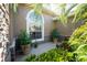 A covered front entry with beautiful, lush tropical plants and a large arched window at 11720 Indian Hills Ln, Clermont, FL 34711