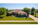 Inviting single-story home with lush landscaping and a well-manicured lawn at 11720 Indian Hills Ln, Clermont, FL 34711